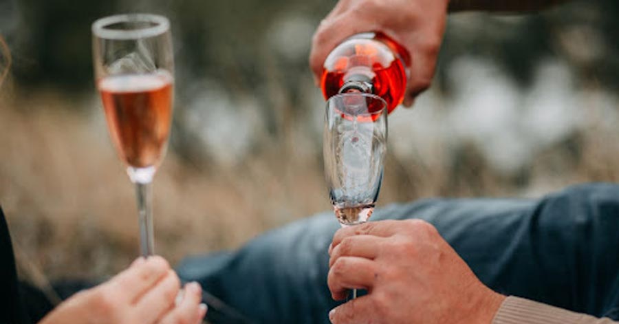 man pouring wine into glass